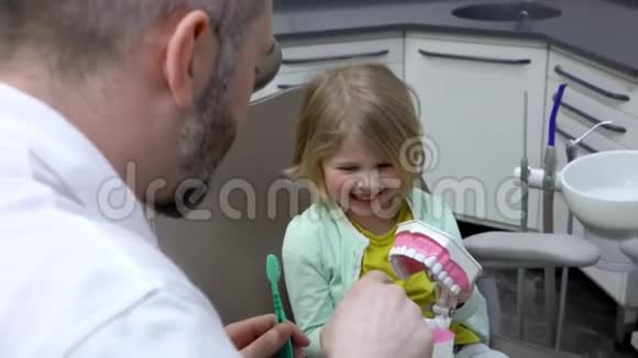 牙医给孩子展示了下巴模型视频的预览图