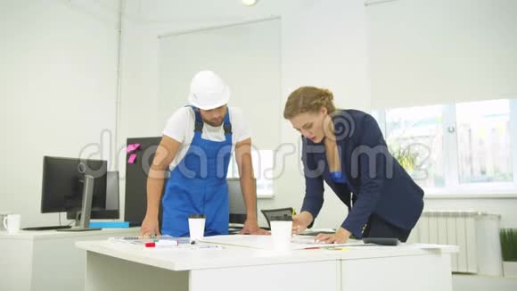 工程师站在女人旁边她用铅笔和尺子在Whatman纸上画画视频的预览图