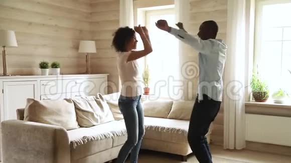 年轻浪漫的黑人夫妇在现代客厅跳舞视频的预览图