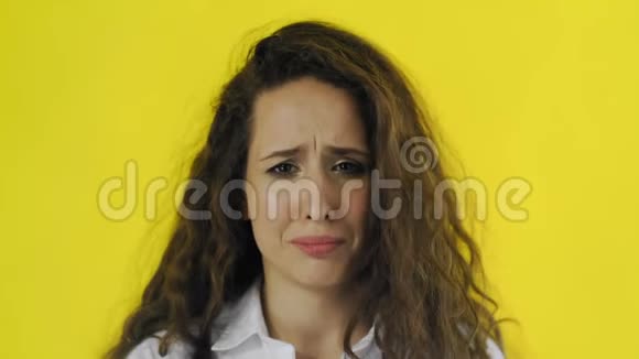 一位年轻漂亮的女人在黄色的银幕上哭泣视频的预览图