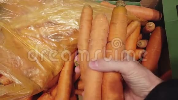 在蔬菜商店或市场上选择胡萝卜的手视频的预览图