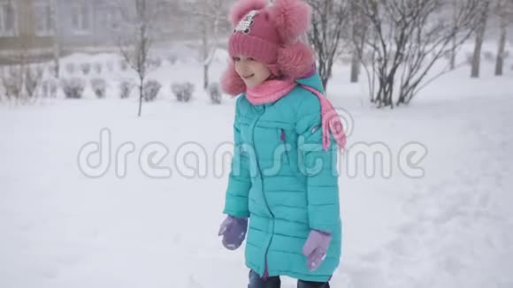 小女孩在冬天用雪雕刻雪人视频的预览图