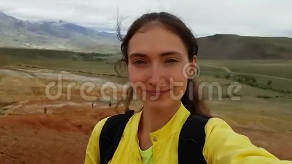 女孩搭便车的黑发女人带着背包在KyzylChinAltai火星的红山上自拍视频的预览图
