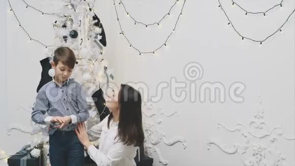 欢快的母子近美丽的装饰圣诞树搂抱着视频的预览图
