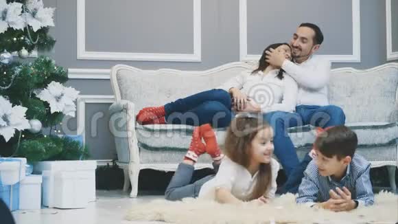 父母坐在沙发上谈论他们的孩子他们也躺在地毯上说话视频的预览图