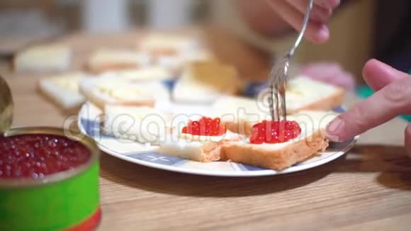 女性手工特写用红色鱼子酱做三明治视频的预览图