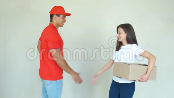 送货服务人员穿制服送包裹给妇女男人拿着盒子微笑着握手视频的预览图