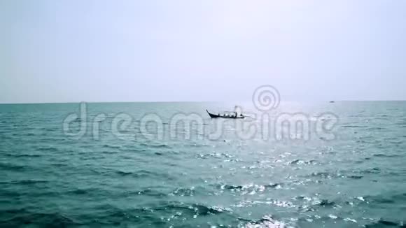 阳光明媚的夏日在开阔的绿松石海中观赏传统的木制长尾船视频的预览图
