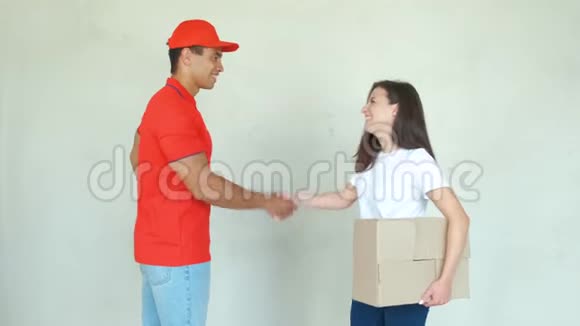 送货服务人员穿制服送包裹给妇女男人拿着盒子微笑着握手视频的预览图