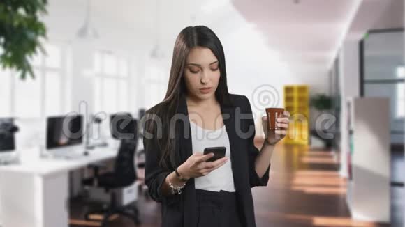 身着咖啡服的商务女性正在办公室使用手机应用程序视频的预览图