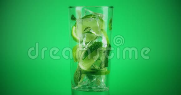在绿色背景下用玻璃做莫吉托鸡尾酒在红色上拍摄特写慢镜头视频的预览图