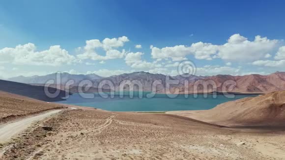 在阳光明媚的日子里在砾石路上向布伦克尔湖飞行帕米尔公路丝绸之路旅行冒险塔吉克斯坦视频的预览图