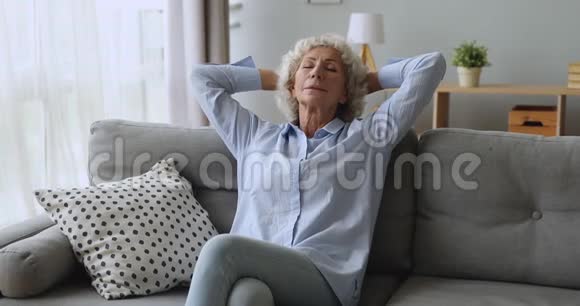 平静安详的老妇人闭着眼睛躺在沙发上视频的预览图