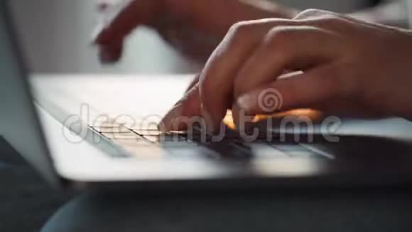 在夕阳下女性用手在笔记本电脑键盘上打字远程工作的概念视频的预览图