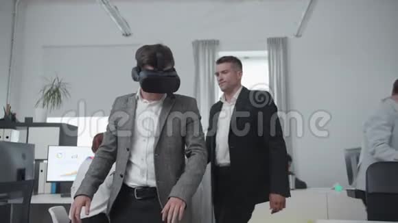 男人正在通过虚拟现实眼镜看办公室视频的预览图