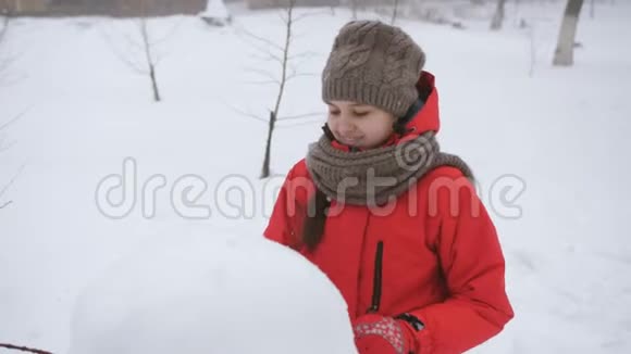 少女在街上玩冬天女孩雕刻雪人雪视频的预览图