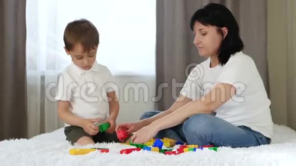 快乐的母亲花时间和她的孩子在彩色积木里玩耍视频的预览图