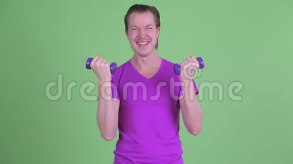 快乐的年轻帅哥用哑铃锻炼身体视频的预览图