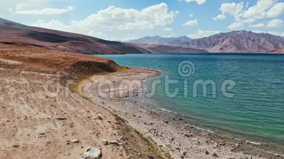阳光明媚的一天飞越布伦克尔湖岸帕米尔公路丝绸之路旅行冒险塔吉克斯坦干旱沙漠中部视频的预览图