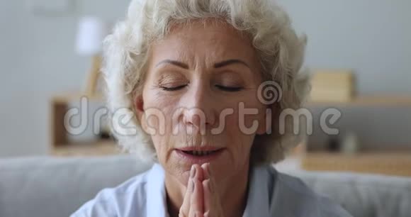 老年妇女在家满怀希望地祈祷近距离观看视频的预览图