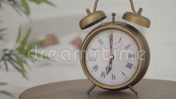 一个老式闹钟的特写显示早上7点两个高加索人在它后面醒来新的开始视频的预览图