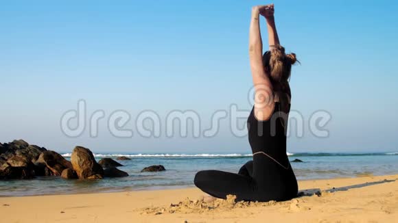 女士伸展背部练习瑜伽运动对抗海洋视频的预览图