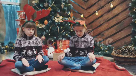圣诞前夜头脑清醒的孩子们戴着驯鹿鹿角想知道他们会得到什么作为礼物视频的预览图