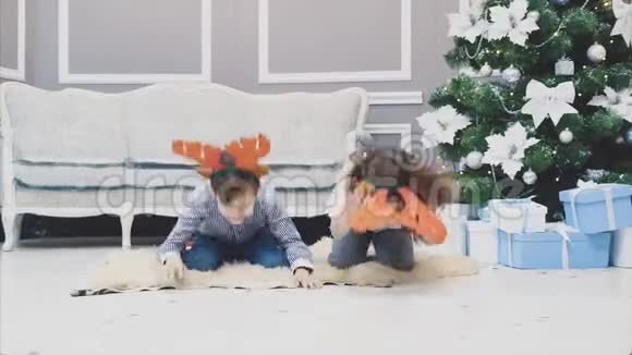 有趣的视频兄弟姐妹穿着圣诞驯鹿鹿角向他们面前的东西鞠躬微笑着看着视频的预览图