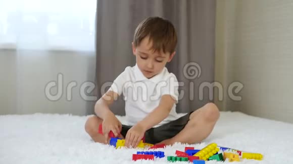 这个孩子用坐在房间里床上的彩色积木搭起来孩子和玩具视频的预览图