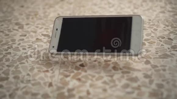 一部手机掉在地板上被举起视频的预览图