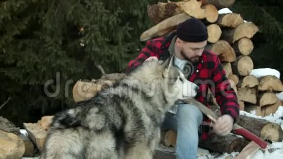 野蛮伐木工人在森林的背景下和一只狗玩耍视频的预览图
