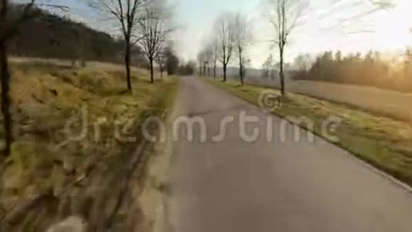 FPV无人驾驶飞机在乡村道路上快速机动飞行并在日落时进行动力循环视频的预览图