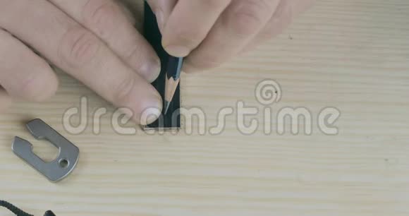 一个工匠手工在皮革上的特写用铅笔标记一条黑色皮革手工制作的产品电影院4k视频视频的预览图