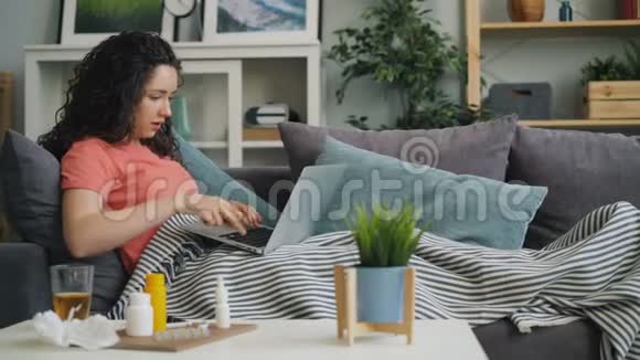 不健康的学生使用笔记本电脑咳嗽在家喝药视频的预览图
