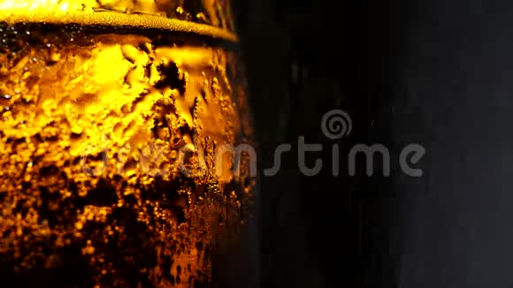 一瓶冷啤酒在黑色背景上缓慢地溅起水花视频的预览图