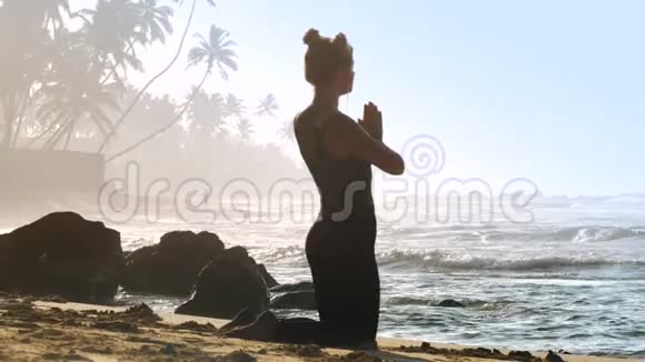 有太空包的女孩在海滩上做瑜伽后摆姿势视频的预览图