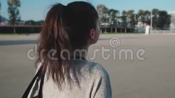 夏日年轻的黑发女子独自漫步在城市后景视频的预览图