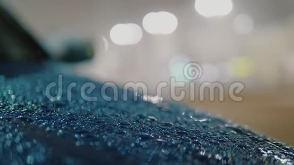 雨和雪落在蓝色的汽车罩上雨滴滴在表面视频的预览图
