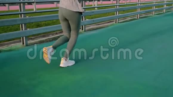 女子正在露天公路上的体育场里奔跑腿部特写镜头视频的预览图