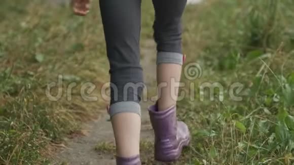 穿着靴子跑腿沿着乡间小路跑踩着小雨坑视频的预览图
