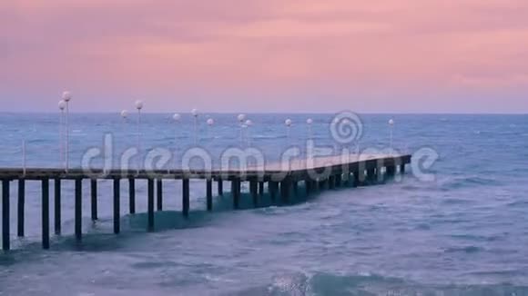 日落时有码头和大海的景观空墩和海面上的小浪视频的预览图
