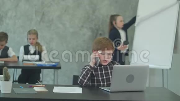 手机上的孩子老板在用笔记本电脑视频的预览图