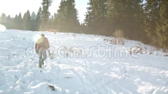 野蛮的伐木工人带着斧头沿着雪坡前进视频的预览图