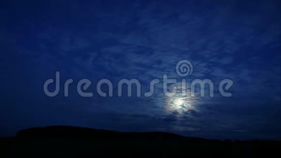 时间流逝神秘的月亮躲在云层后面在黑暗的天空中闪闪发光视频的预览图
