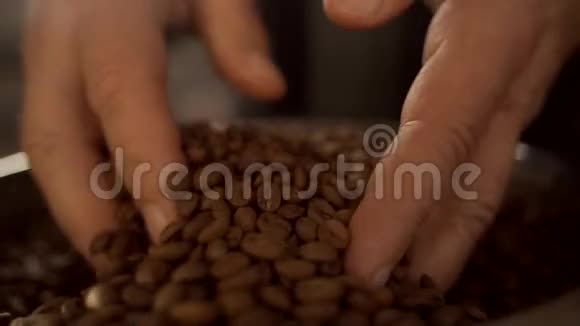 一个人用手混合不同品种的烤咖啡豆手和咖啡豆特写视频的预览图
