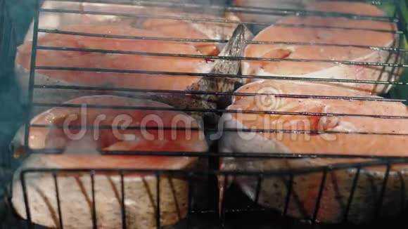 生鳟鱼牛排在木炭烤架上煎炸烧烤时吃三文鱼视频的预览图
