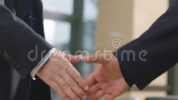 商务人员在办公室握手问候的特写视频的预览图
