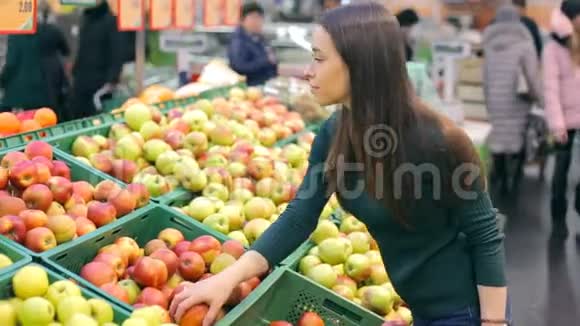 在食品杂货店挑选新鲜红苹果的女人视频的预览图