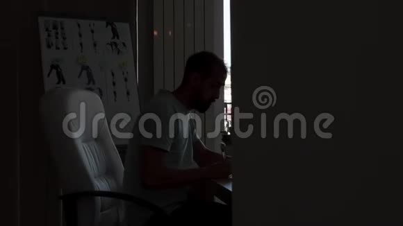 有经验的设计师坐在办公桌上一边用电脑工作视频的预览图