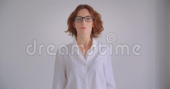 戴眼镜的白种人成年女商人用双臂交叉在胸前看镜头的特写照片视频的预览图
